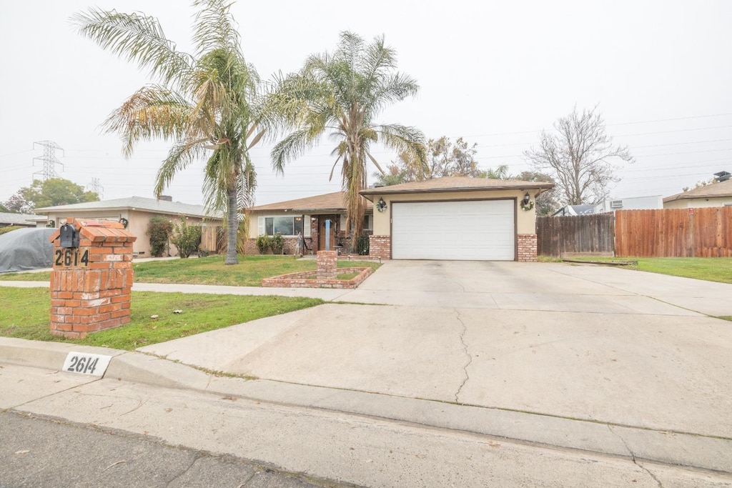 ranch-style house featuring a front lawn and a garage