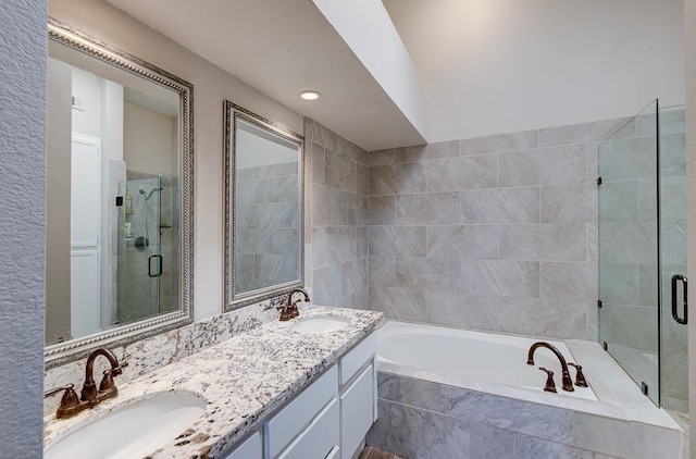 bathroom featuring vanity and independent shower and bath