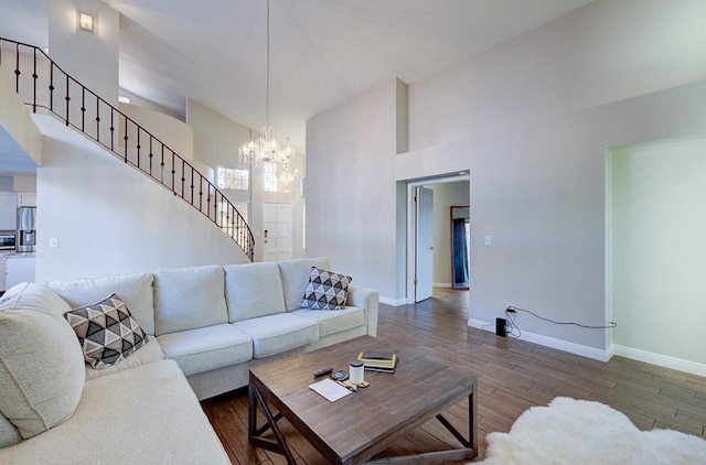 living room featuring a towering ceiling, dark wood-type flooring, and a chandelier