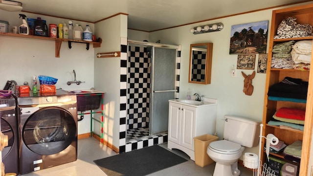 bathroom featuring vanity, washer and dryer, toilet, concrete flooring, and a shower with shower door