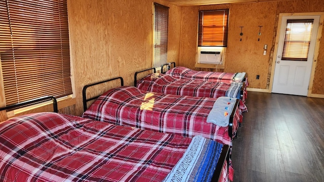 bedroom with wood walls, dark hardwood / wood-style floors, and cooling unit