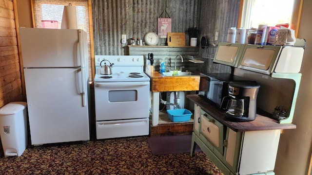 kitchen with wooden walls, sink, and white appliances