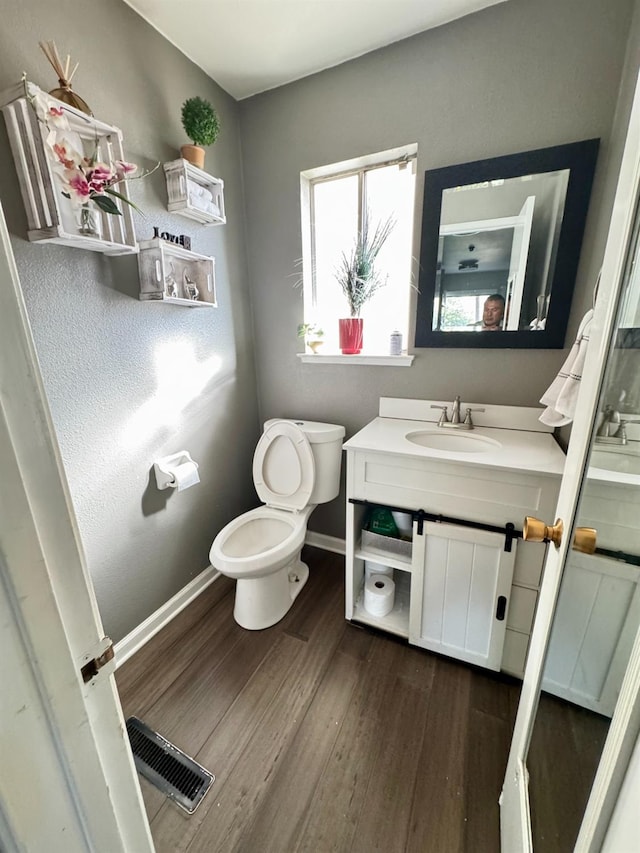 bathroom with hardwood / wood-style floors, vanity, and toilet