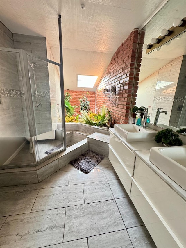 bathroom with vaulted ceiling with skylight, vanity, brick wall, and walk in shower