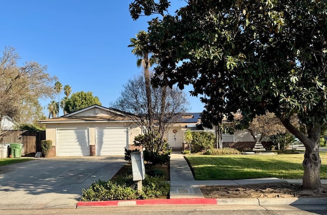 single story home with a front yard, solar panels, and a garage