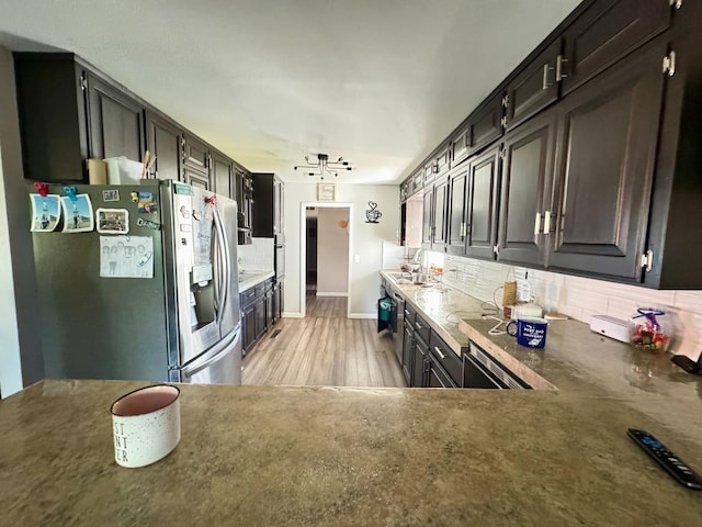 kitchen featuring backsplash, stainless steel fridge with ice dispenser, sink, and light hardwood / wood-style floors