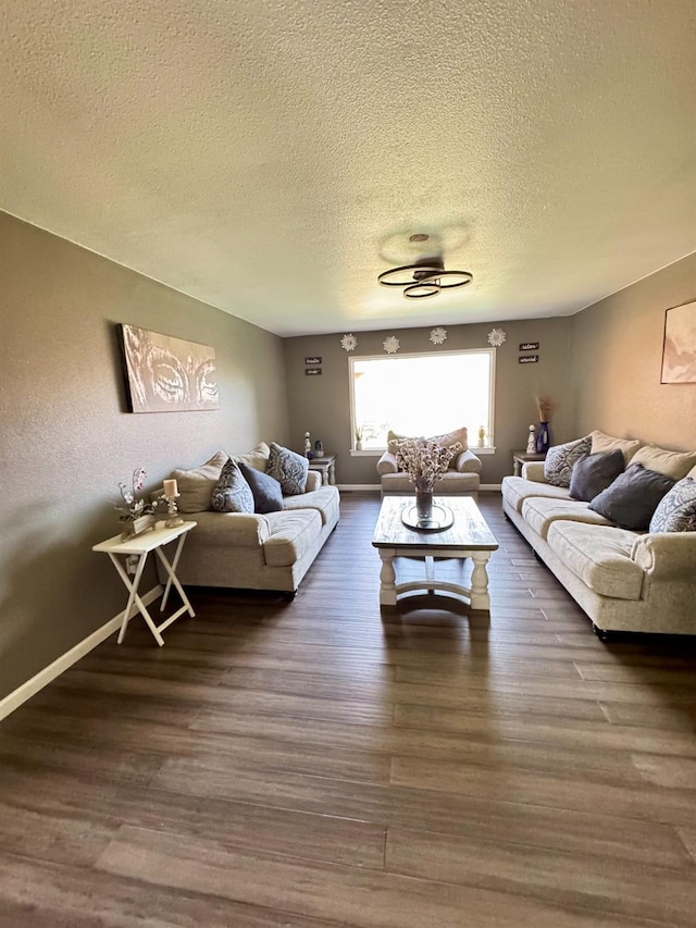 living room with a textured ceiling and dark hardwood / wood-style floors