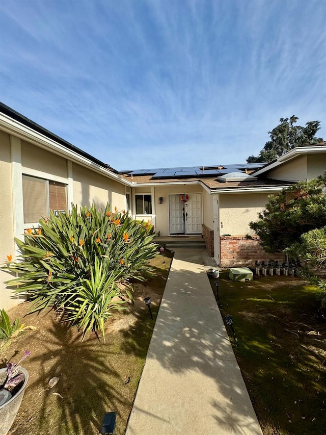 view of front of property featuring solar panels