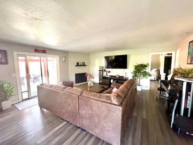 living room with a fireplace, wood-type flooring, and a textured ceiling