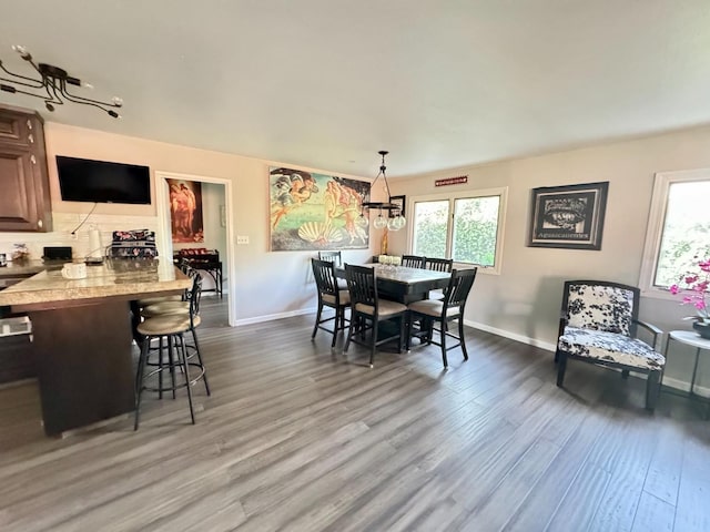 dining space with hardwood / wood-style flooring and a notable chandelier