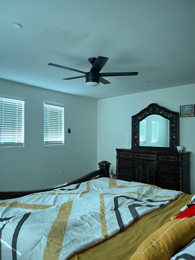 bedroom with ceiling fan and a textured ceiling