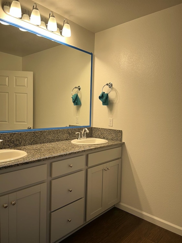 bathroom featuring hardwood / wood-style floors, vanity, and a textured ceiling