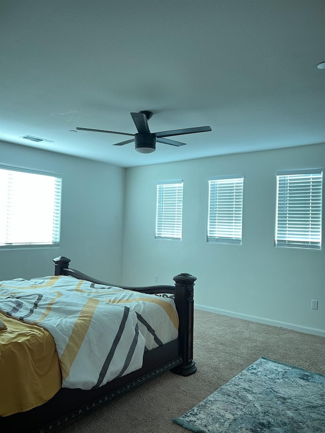 bedroom with carpet, ceiling fan, and multiple windows