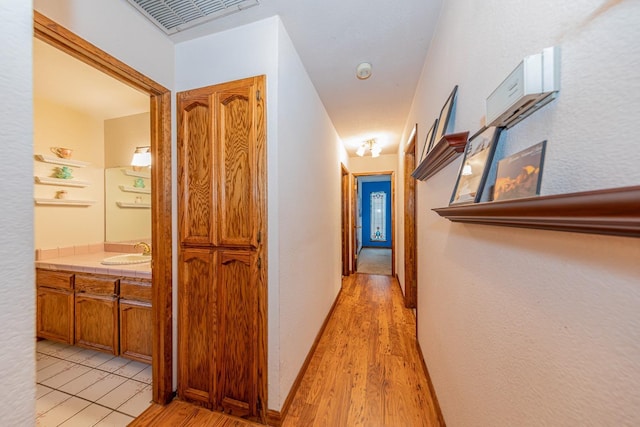 50365 Spook Ln, Oakhurst, CA 93644 - hallway with a sink, baseboards, light wood finished floors, and visible vents