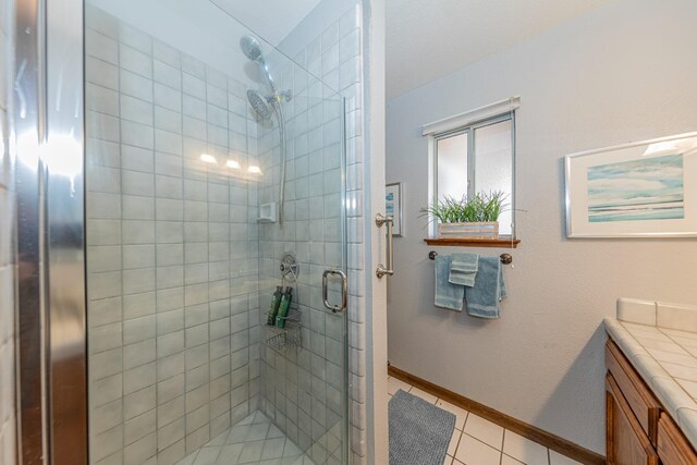50365 Spook Ln, Oakhurst, CA 93644 - full bath featuring a stall shower, baseboards, vanity, and tile patterned floors