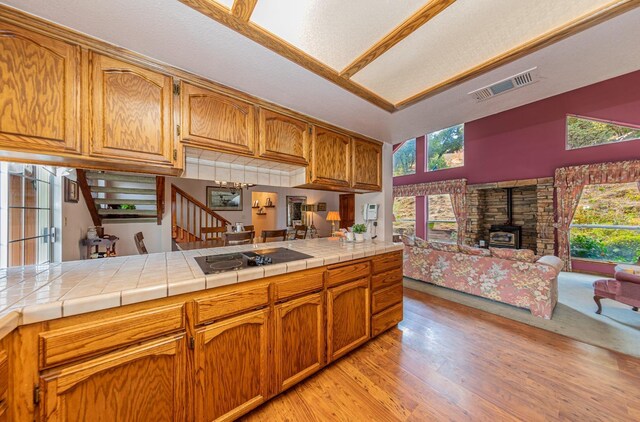 50365 Spook Ln, Oakhurst, CA 93644 - kitchen with black electric cooktop, visible vents, light wood-style floors, open floor plan, and a wood stove