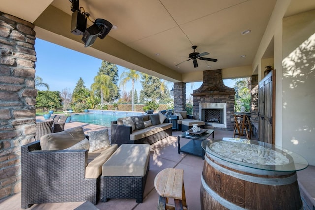 view of patio / terrace featuring an outdoor living space with a fireplace and ceiling fan