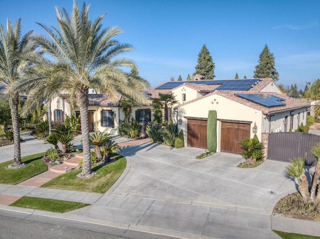 mediterranean / spanish-style home featuring solar panels and a garage