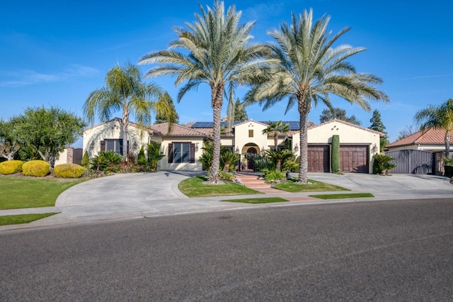 mediterranean / spanish-style home featuring a garage and solar panels