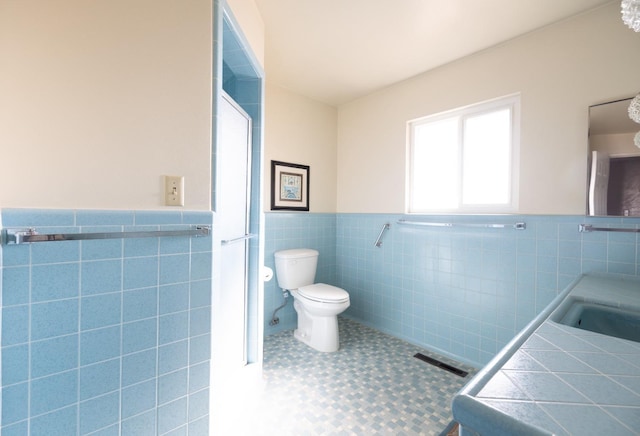 bathroom featuring visible vents, toilet, a wainscoted wall, tile patterned floors, and tile walls