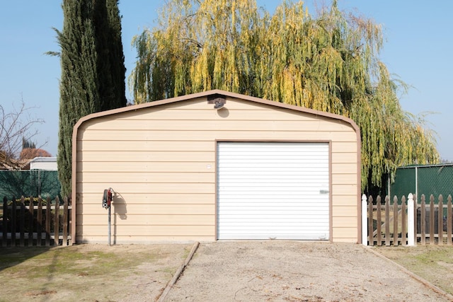 detached garage with driveway and fence