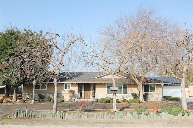 single story home featuring stone siding, fence, and stucco siding