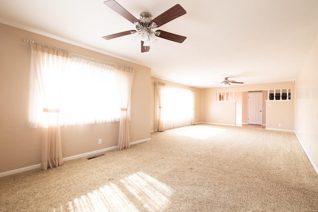 empty room with a ceiling fan, carpet, visible vents, and baseboards