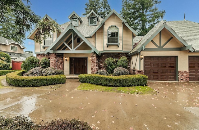 view of front of home featuring a garage, brick siding, driveway, and stone siding