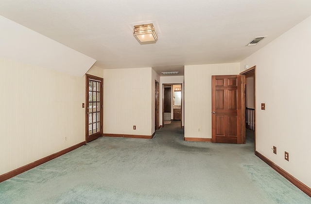spare room with carpet, visible vents, and baseboards