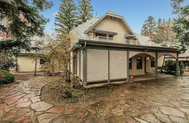 view of home's exterior featuring a balcony and a patio