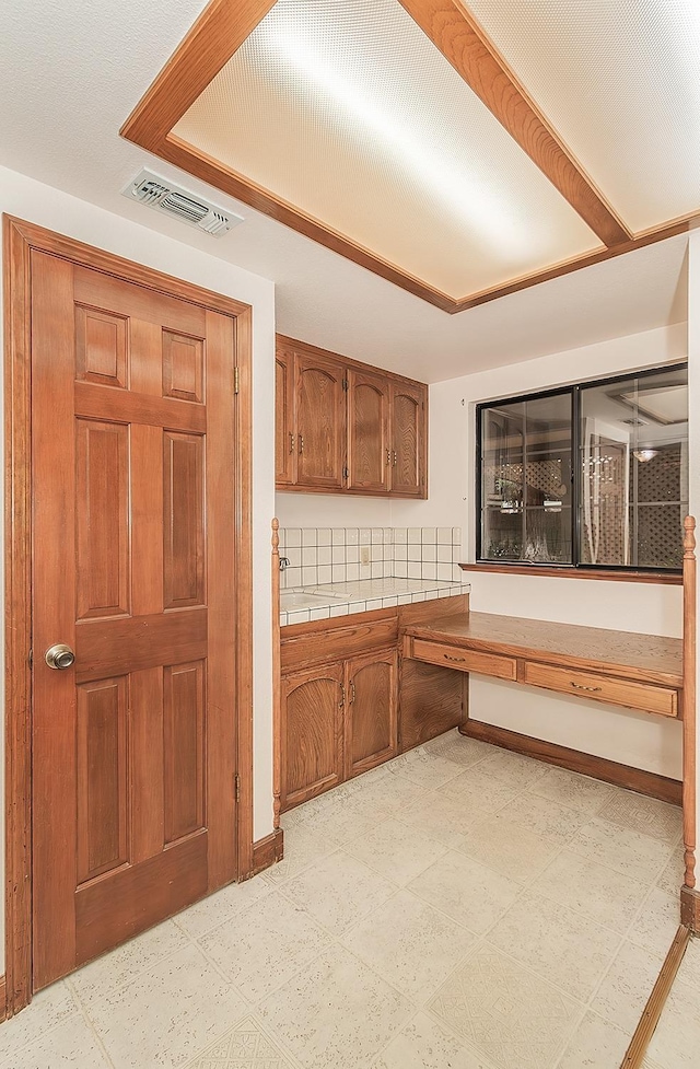kitchen with visible vents and brown cabinetry