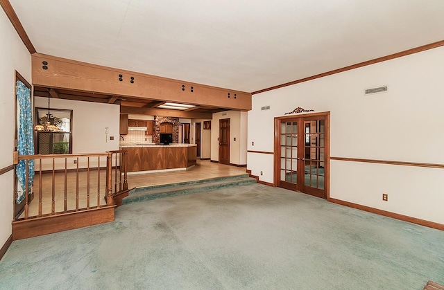 carpeted living room with crown molding and french doors