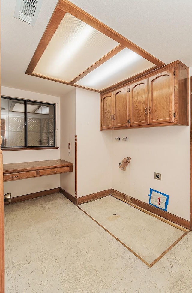 washroom featuring gas dryer hookup, electric dryer hookup, visible vents, baseboards, and cabinet space