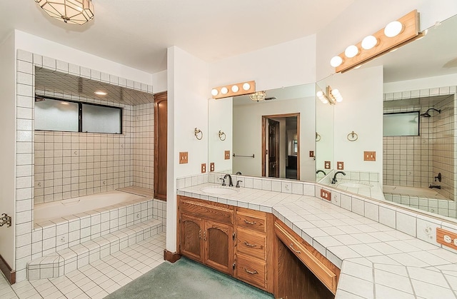 bathroom featuring tile patterned floors, tiled bath, and vanity