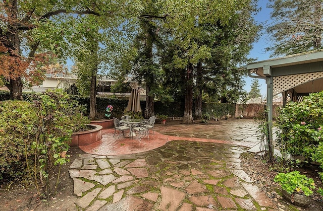view of yard featuring outdoor dining area, a fenced backyard, and a patio area