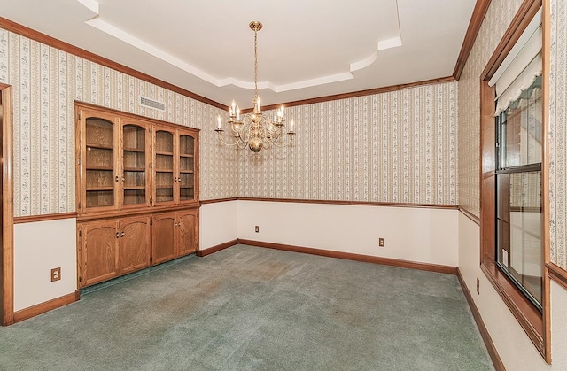 carpeted empty room featuring crown molding, wallpapered walls, a chandelier, and a tray ceiling