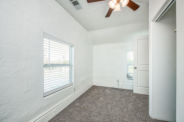 unfurnished room featuring ceiling fan and dark colored carpet