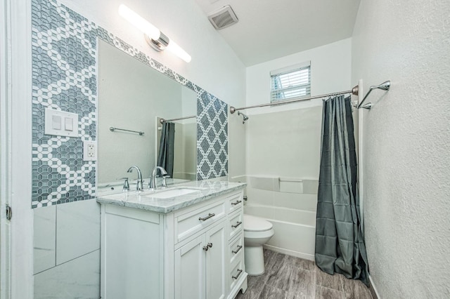 full bathroom with hardwood / wood-style floors, vanity, shower / bath combination with curtain, and toilet