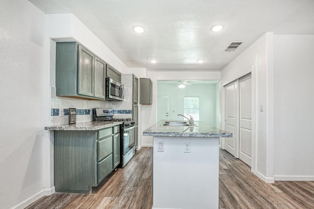 kitchen with ceiling fan, stainless steel appliances, dark hardwood / wood-style floors, and sink