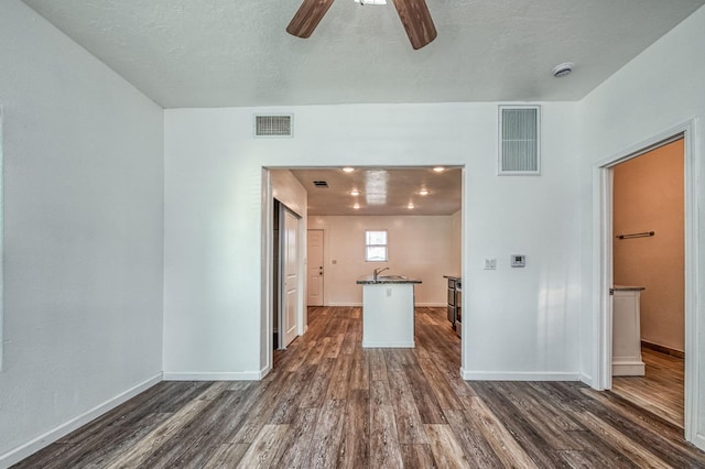 interior space featuring dark hardwood / wood-style floors, ceiling fan, sink, and a textured ceiling