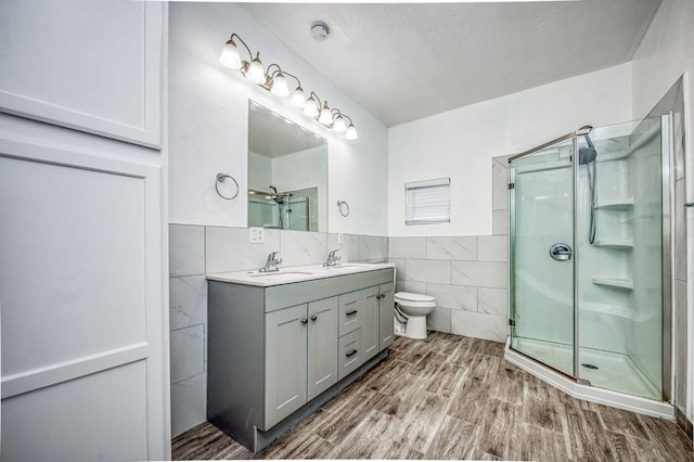 bathroom featuring walk in shower, toilet, vanity, tile walls, and hardwood / wood-style flooring