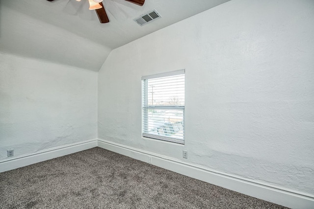 carpeted spare room featuring ceiling fan and vaulted ceiling