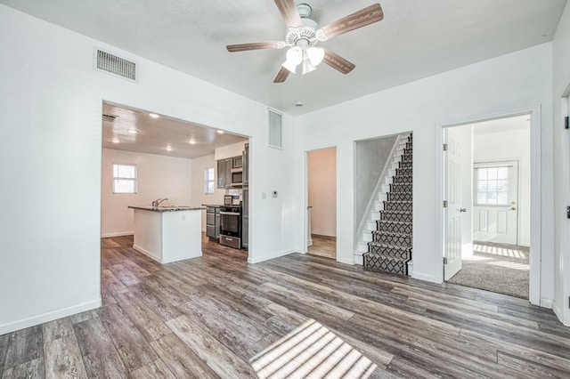 unfurnished living room featuring hardwood / wood-style flooring, a wealth of natural light, and ceiling fan