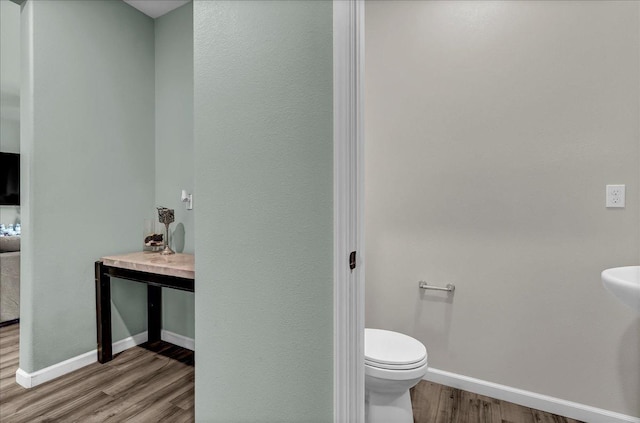 bathroom with hardwood / wood-style flooring and toilet