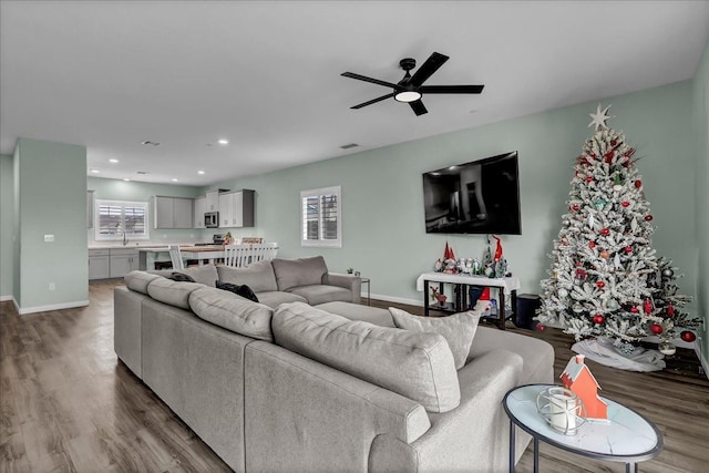 living room with hardwood / wood-style flooring, ceiling fan, and sink