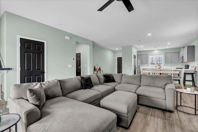 living room with light wood-type flooring and ceiling fan