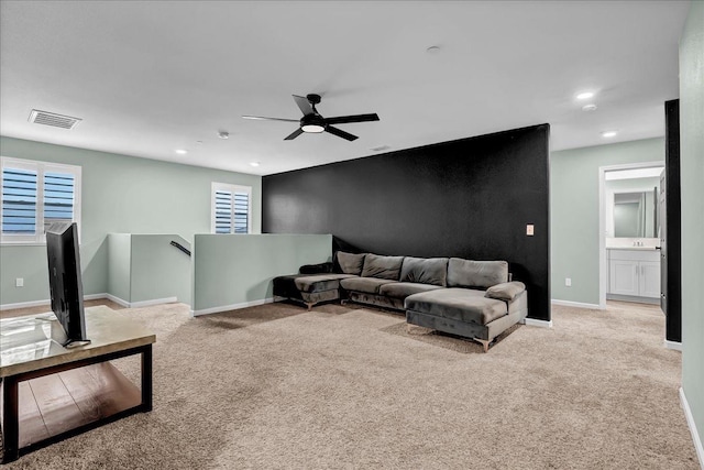 carpeted living room with ceiling fan