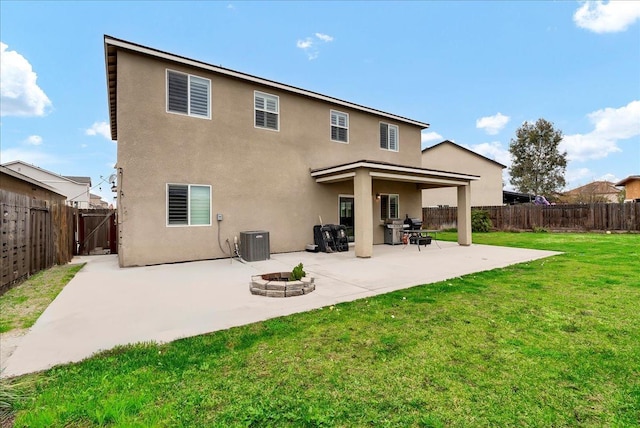 rear view of house featuring central AC unit, a fire pit, a lawn, and a patio area