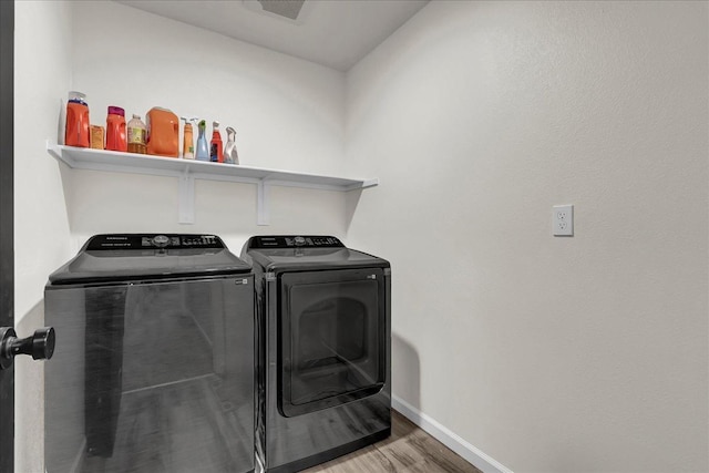 clothes washing area featuring separate washer and dryer and wood-type flooring