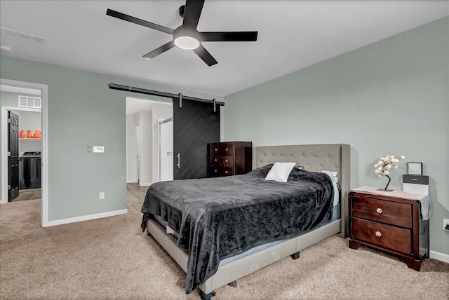 bedroom with a barn door, light colored carpet, and ceiling fan